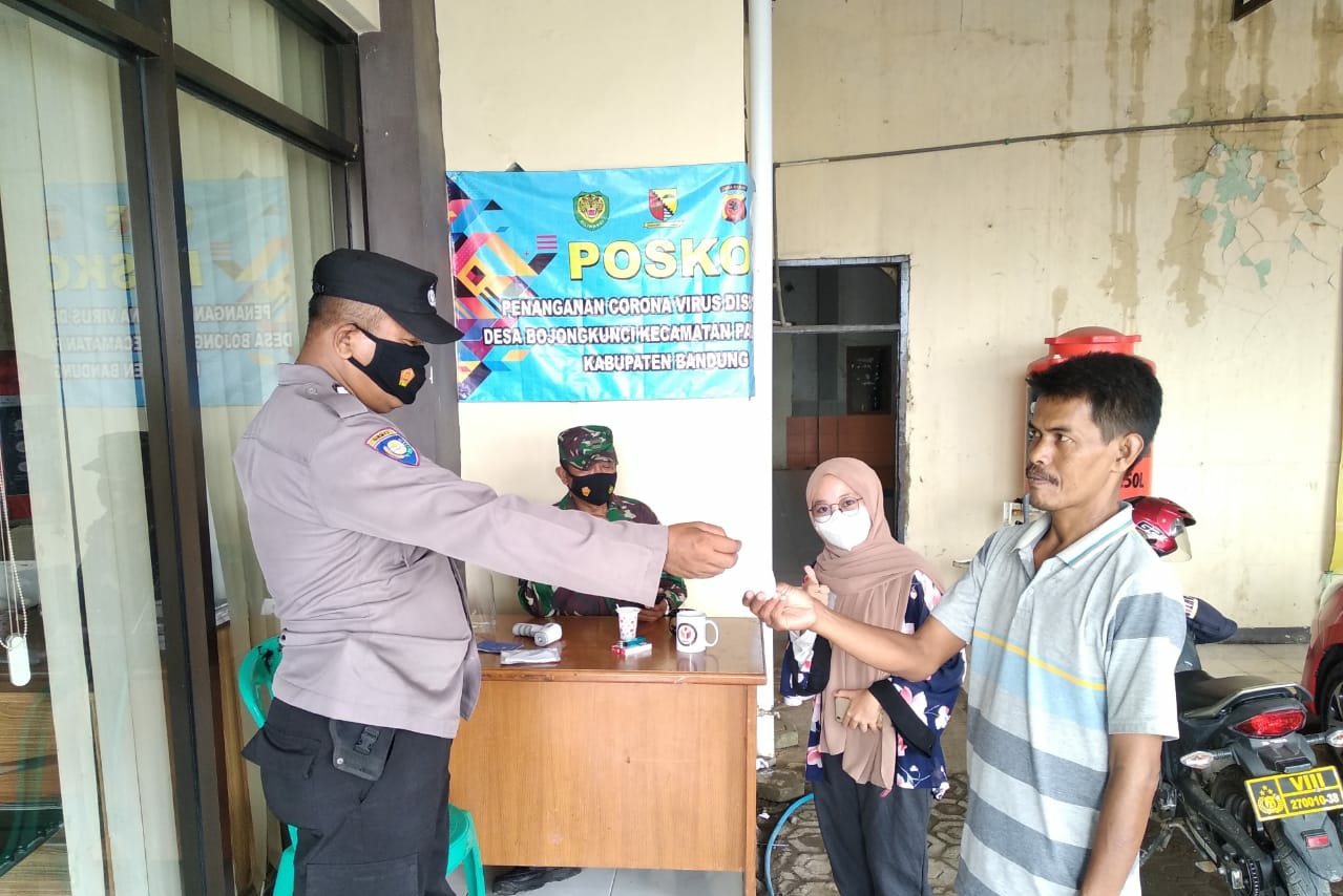 Bhabinkamtibmas Polsek Pameungpeuk Polresta Bandung Bagikan Masker di Posko PPKM Desa Bojongkunci