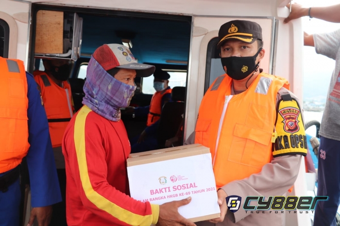 Dari Atas Kapal Patroli, Polisi Bagikan Bansos Sembako Kepada Nelayan