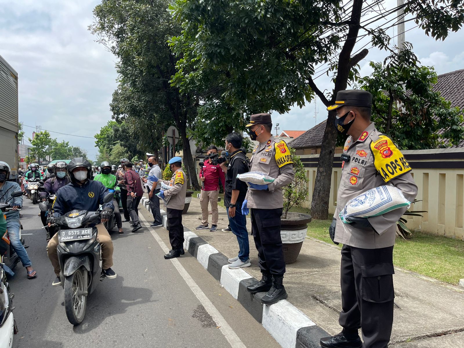 Polisi Bagikan Bansos Beras Ke Para Pengendara Jalan Raya Dalam Rangka Ops Patuh Lodaya 2021