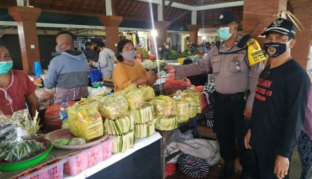 Bhabinkamtibmas Dampingi Satpol PP Razia Masker di Pasar Penarungan