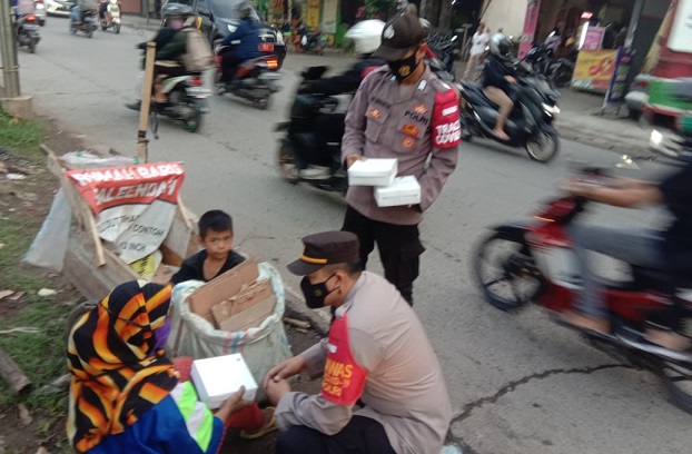 Peduli Sesama di Bulan Suci Ramadhan, Personel Polresta Bandung Bagikan Nasi Kotak untuk Warga 