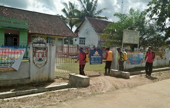 Babinsa dan Aparat Desa Gotong Royong Semprot Disinfektan