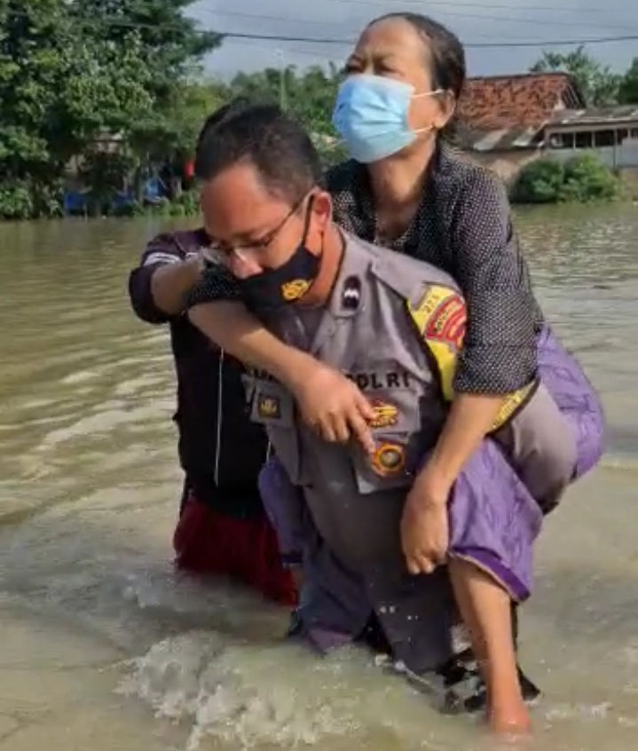 Bhabinkamtibmas Desa Sukamakmur Gendong Ibu-Ibu Saat Evakuasi Korban Banjir di Wilkum Polres Karawang Polda Jabar