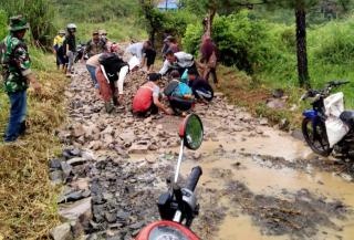 Meski Hujan Mengguyur, Warga Antusias Perbaiki Jalan yang Rusak Parah