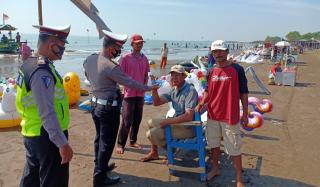 Polres Indramayu Bagikan Masker Gratis Kepada Pengunjung Pantai Glayem